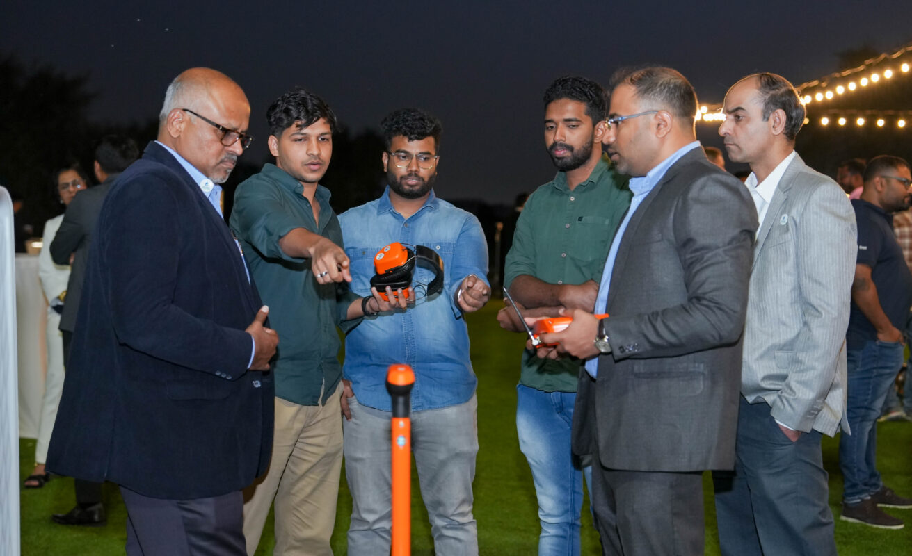 Group of men engaged in a hands-on product demonstration at the Moosa-Daly 2025 Product Show in Dubai.