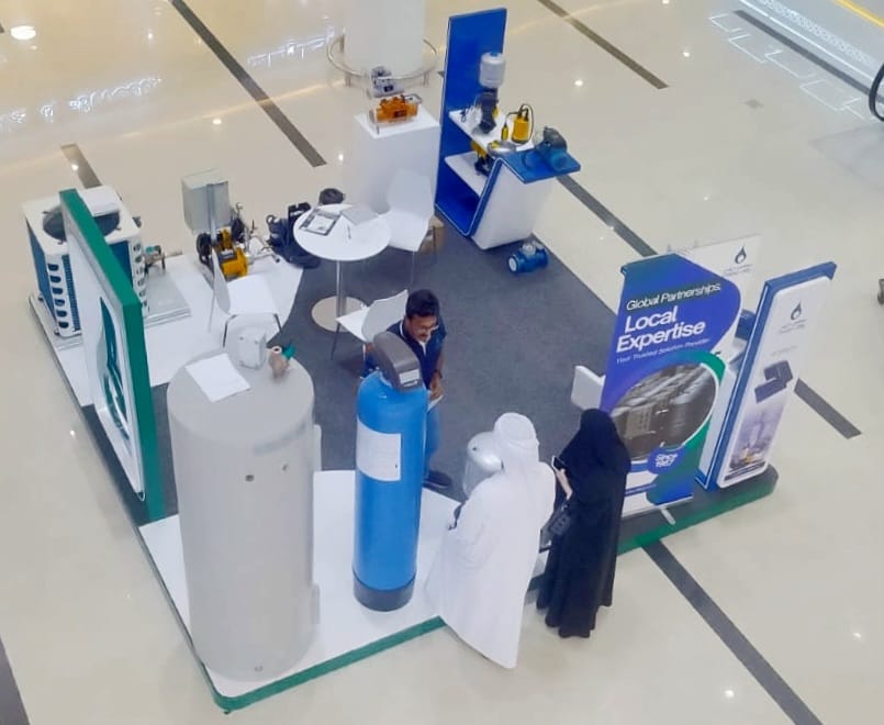 Overhead view of Moosa-Daly’s exhibition booth at Madinat Zayed, featuring water treatment systems and engaged visitors.