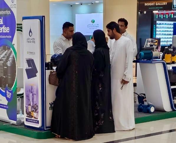Moosa-Daly representative engaging with visitors at the Madinat Zayed event booth.